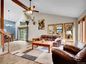 Spacious living room with vaulted ceilings, wood floors, and plenty of natural light from windows at 26765 Bradley St, Conifer, CO 80433