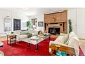 Inviting living room featuring a cozy brick fireplace and comfortable seating arrangements at 4730 W Moncrieff Pl, Denver, CO 80212