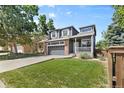 Two-story home featuring a front yard with lush green grass, mature trees, and a two-car garage at 10295 Ravenswood Ln, Highlands Ranch, CO 80130