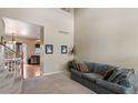 Spacious living room featuring high ceilings, a comfortable sofa, and views into the kitchen at 10295 Ravenswood Ln, Highlands Ranch, CO 80130
