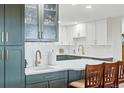 Kitchen features white cabinets, green island, bar seating, and stainless steel hardware at 13850 E Marina Dr # 606, Aurora, CO 80014