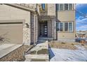 Front entrance with stonework and a modern door. Steps lead up to the covered entryway at 14461 Mosaic Ave, Parker, CO 80134