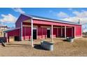 Spacious red barn with multiple stalls and metal water troughs, perfect for horses or other livestock at 200 Bothun Rd, Berthoud, CO 80513