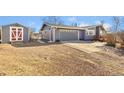 Attached two-car garage and shed in the backyard, featuring a gravel driveway and brick trim at 200 Bothun Rd, Berthoud, CO 80513