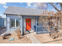 Close-up of a charming blue home with a covered porch and a vibrant orange front door at 103 Sunset St # A, Longmont, CO 80501