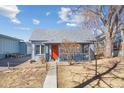 Charming blue home with a covered porch and a vibrant orange front door at 103 Sunset St # A, Longmont, CO 80501