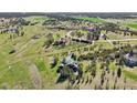 Expansive aerial view showcases a log home with acreage and beautiful landscaping set among mature trees at 3557 Palmer Ridge Dr, Parker, CO 80134