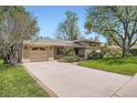Spacious front yard with a long driveway leading to a single car garage in a charming home at 4490 Balsam St, Wheat Ridge, CO 80033