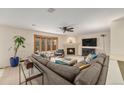Bright living room with fireplace, large bay window, plush gray sectional and neutral carpet at 6235 W Floyd Ave, Denver, CO 80227