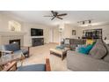 Comfortable living room featuring a cozy fireplace, plush seating, a ceiling fan and neutral carpet at 6235 W Floyd Ave, Denver, CO 80227
