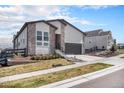 Charming two-story home featuring stone accents, siding, a well-manicured lawn, and a two-car garage at 7202 Canyonpoint Rd, Castle Pines, CO 80108
