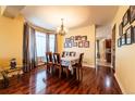 Formal dining room with hardwood floors, elegant chandelier, and large windows providing natural light at 3902 Eagle Tail Ln, Castle Rock, CO 80104