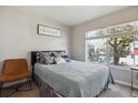 Bright bedroom featuring a comfortable bed, a chair, and a large window overlooking the outdoors at 9300 E Florida Ave # 1107, Denver, CO 80247