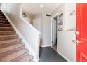 Welcoming entryway featuring carpeted stairs, white trim, gray accent flooring, and decorative wall art at 9300 E Florida Ave # 1107, Denver, CO 80247