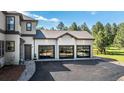 Detached three-car garage with modern glass doors and neutral stucco, providing ample parking and storage space at 230 S Big Meadow Trl, Franktown, CO 80116