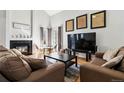 Bright living room with a fireplace, large TV, neutral paint, and comfortable seating at 5425 W 115Th Pl, Westminster, CO 80020