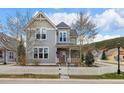 Inviting home featuring a covered front porch, complemented by a white picket fence and mature trees at 45 Bridge St, Breckenridge, CO 80424