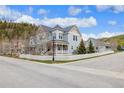 Stylish home showcasing a well-manicured lawn, mature trees, and a charming covered front porch at 45 Bridge St, Breckenridge, CO 80424