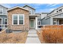 Charming townhome with stone accents, a green front door, and a well-maintained yard at 14284 W 88Th Dr # B, Arvada, CO 80005