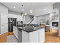 Spacious kitchen island with black countertop, stainless steel appliances, and adjacent fireplace at 14284 W 88Th Dr # B, Arvada, CO 80005