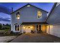 Inviting front porch with dual doors and outdoor seating, illuminated by warm lighting, exudes curb appeal at 8370 Midsummer Ln, Elizabeth, CO 80107