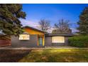 Single-story brick home with a modern front door, large windows, and mature trees at 2320 S Valley Hwy, Denver, CO 80222