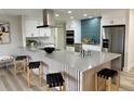 Kitchen with stainless steel appliances, large kitchen island with seating and modern overhead exhaust at 2320 S Valley Hwy, Denver, CO 80222
