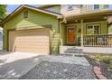 Inviting home exterior with a two-car garage, updated landscaping, and a cozy covered porch at 676 Hedgerow Way, Brighton, CO 80601
