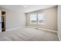 A spacious, carpeted main bedroom with large windows offering natural light at 2443 W 69Th Pl, Denver, CO 80221