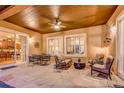 Covered outdoor patio featuring stone flooring, a ceiling fan, and comfortable seating arrangements at 2571 Hunters Pl, Highlands Ranch, CO 80129