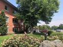 Charming brick building with lush greenery, colorful flowers, and mature trees enhancing its curb appeal at 1201 Balsam Ave # 203, Boulder, CO 80304