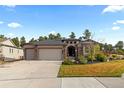 Inviting single-story home with a three-car garage and landscaped front yard at 1734 Summerglow Ln, Monument, CO 80132