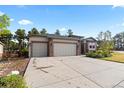Attached three-car garage with large concrete driveway and meticulously maintained landscaping at 1734 Summerglow Ln, Monument, CO 80132