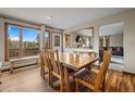Bright dining room features wood table, mountain views, and access to the home's deck at 24 Ski Pole Ct, Breckenridge, CO 80424