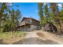 View of home's exterior featuring a private drive, shed, mature trees, and multiple porches at 24 Ski Pole Ct, Breckenridge, CO 80424
