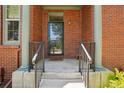 Close-up of the front entrance featuring brick columns, decorative railings, and a welcoming doormat at 2933 Central Park Blvd, Denver, CO 80238