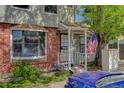 Charming townhome entrance featuring a covered porch, brick accents, and a welcoming American flag at 8144 Washington St # 192, Denver, CO 80229