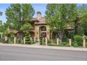 Stunning home exterior with manicured landscaping, mature trees, and a clay tile roof at 5335 E 2Nd Ave, Denver, CO 80220
