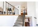 Interior staircase with carpet runner and iron railing leading to the home's second level at 2161 Bowen St, Longmont, CO 80501