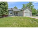 Inviting single-story home featuring a lush green lawn and attached two-car garage at 9406 Troon Village Way, Lone Tree, CO 80124