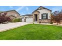 Attractive single-Gathering home featuring stone accents, a lush green lawn, and a three-car garage at 21376 E Union Pl, Aurora, CO 80015