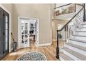 Inviting foyer with hardwood floors, staircase, and office with glass door at 3163 Soaring Eagle Ln, Castle Rock, CO 80109