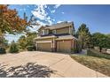 Spacious three-car garage with a large concrete driveway and beautiful landscaping at 3163 Soaring Eagle Ln, Castle Rock, CO 80109