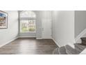 Bright foyer features wood flooring, a large window, and a staircase to the upper level at 10591 Hyacinth St, Highlands Ranch, CO 80129