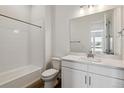 Bright bathroom with white cabinets, white subway tile shower, and modern fixtures at 8672 Pennycress Dr, Littleton, CO 80125