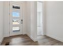 Bright entryway with a modern front door, wood-look flooring and an open view into other rooms at 8672 Pennycress Dr, Littleton, CO 80125