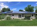 Backyard view of home showing solar panels, sliding glass door, and large lawn in a quiet, residential neighborhood at 3910 E Orchard Rd, Centennial, CO 80121