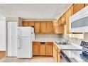 Functional kitchen featuring wood cabinets, tiled floor, and essential appliances at 8826 E Florida Ave # 117, Denver, CO 80247