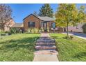 Brick home with landscaped yard and stone walkway at 1160 Holly St, Denver, CO 80220