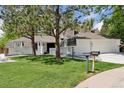 Charming home featuring mature trees, green lawn, and a spacious three-car garage at 6075 S Filbert Ct, Centennial, CO 80121